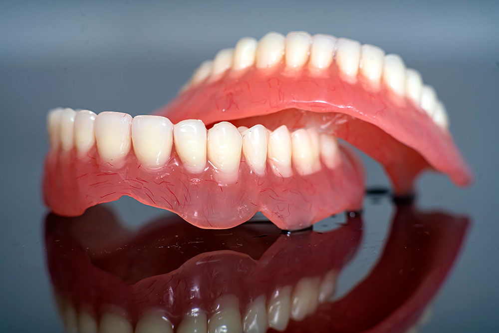Съемные протезы с искусственными зубами и деснами на всю верхнюю и нижнюю челюсть