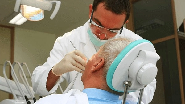 Врач осматривает состояние полости рта после имплантации