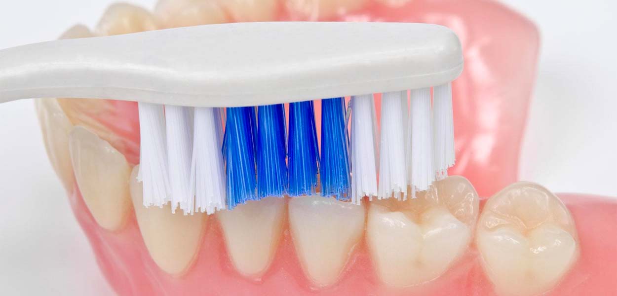 Чистка нейлонового протеза зубной щеткой с мягкой щетиной