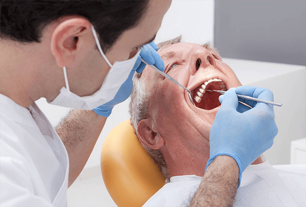 На первом приёме хирург-имплантолог осматривает полость рта пациента, опрашивает и консультирует