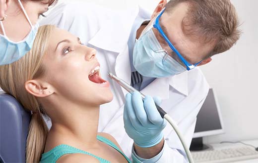 Стоматолог проводит подготовительные мероприятия перед имплантацией зубов